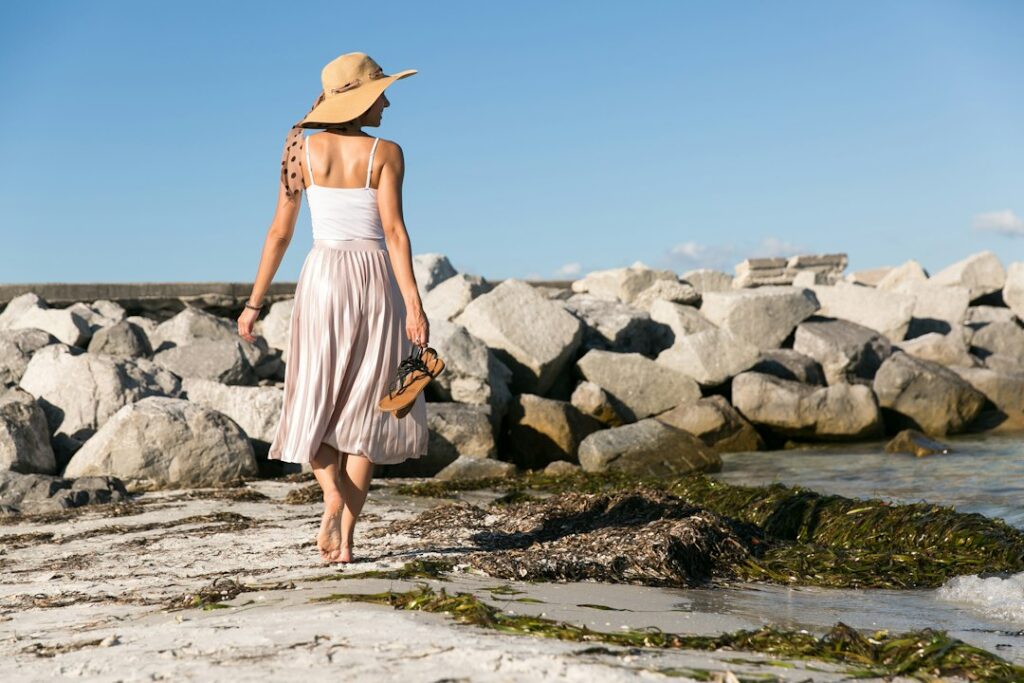 Woman in a sun hat at the beach illustrating microneedling aftercare planning in Merritt Island