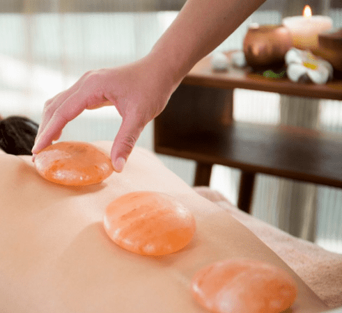 Himalayan salt stone therapy massage add-on at iOnyx Medspa Merritt Island for detox, circulation, and deep relaxation